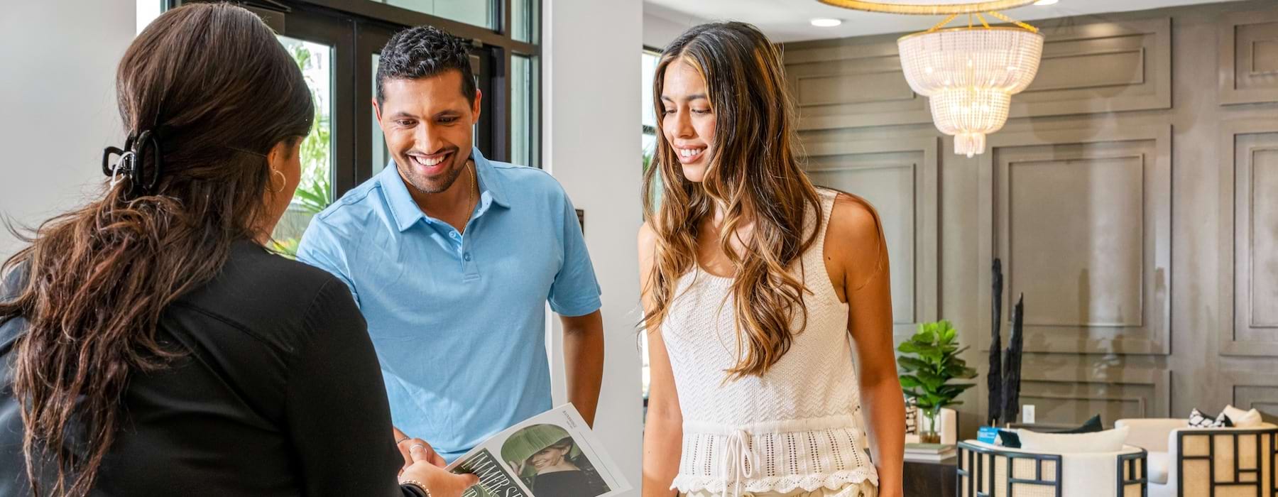 man and two woman looking at a brochure